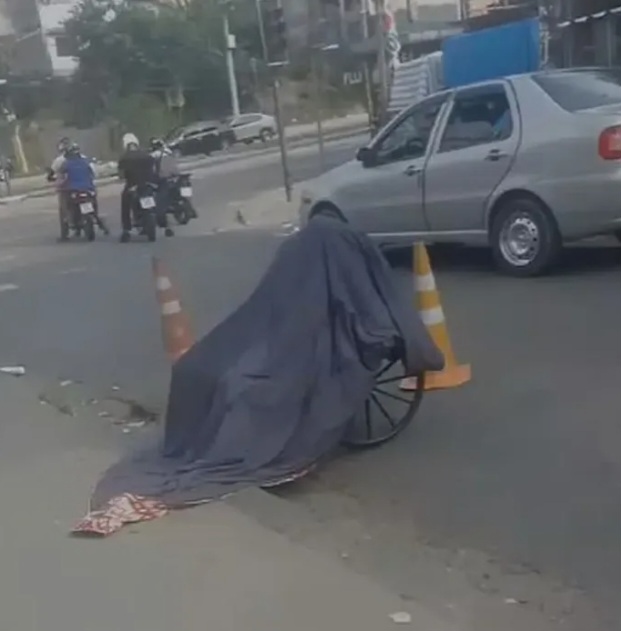 Homem carrega corpo da mãe em cadeira de rodas pelas ruas